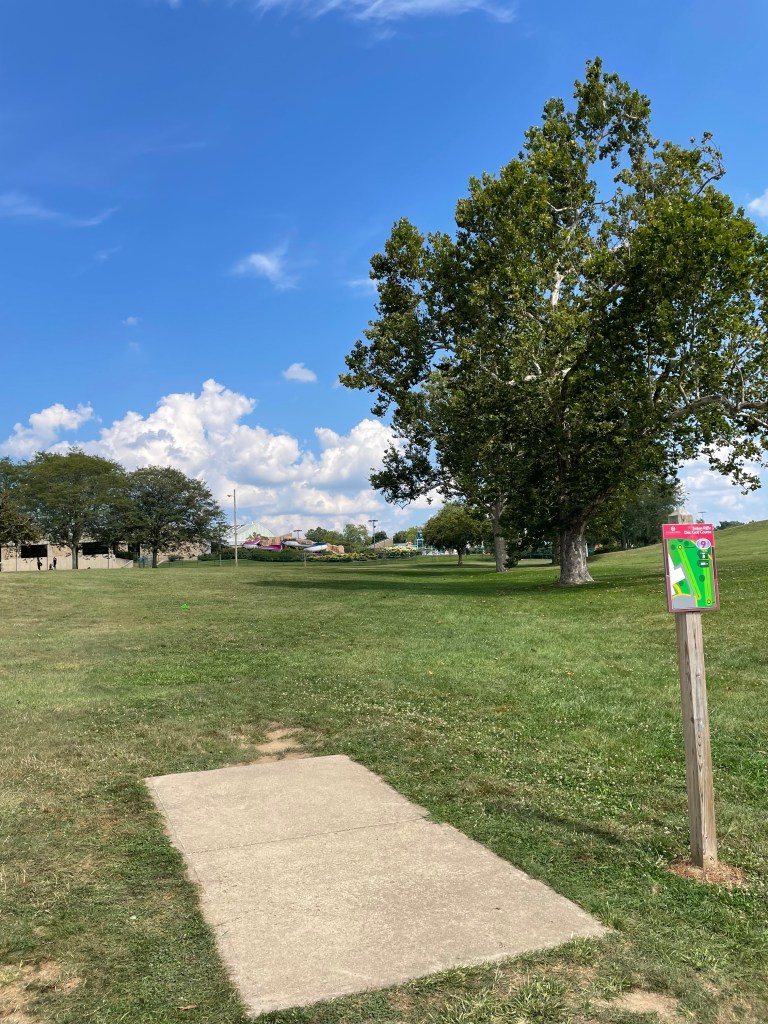 disc golf tee block, on a sunny day with fluffy clouds in the background